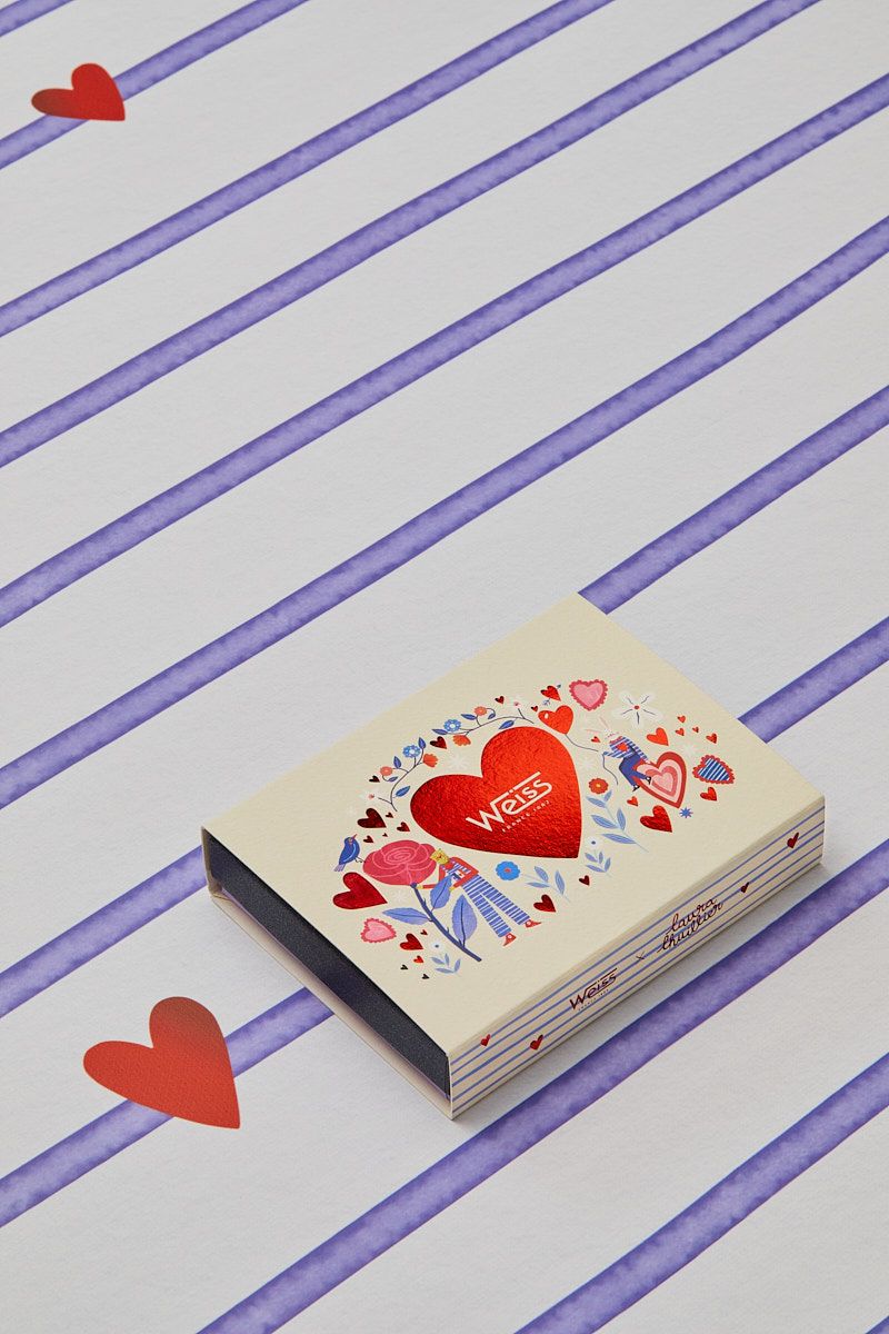 Valentine's chocolate box with heart design on purple striped background.