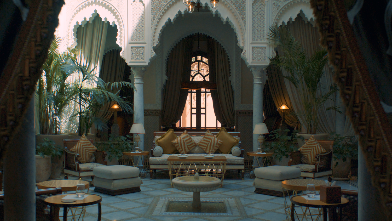 Elegant Moroccan riad interior with arched doorways and traditional furnishings.
