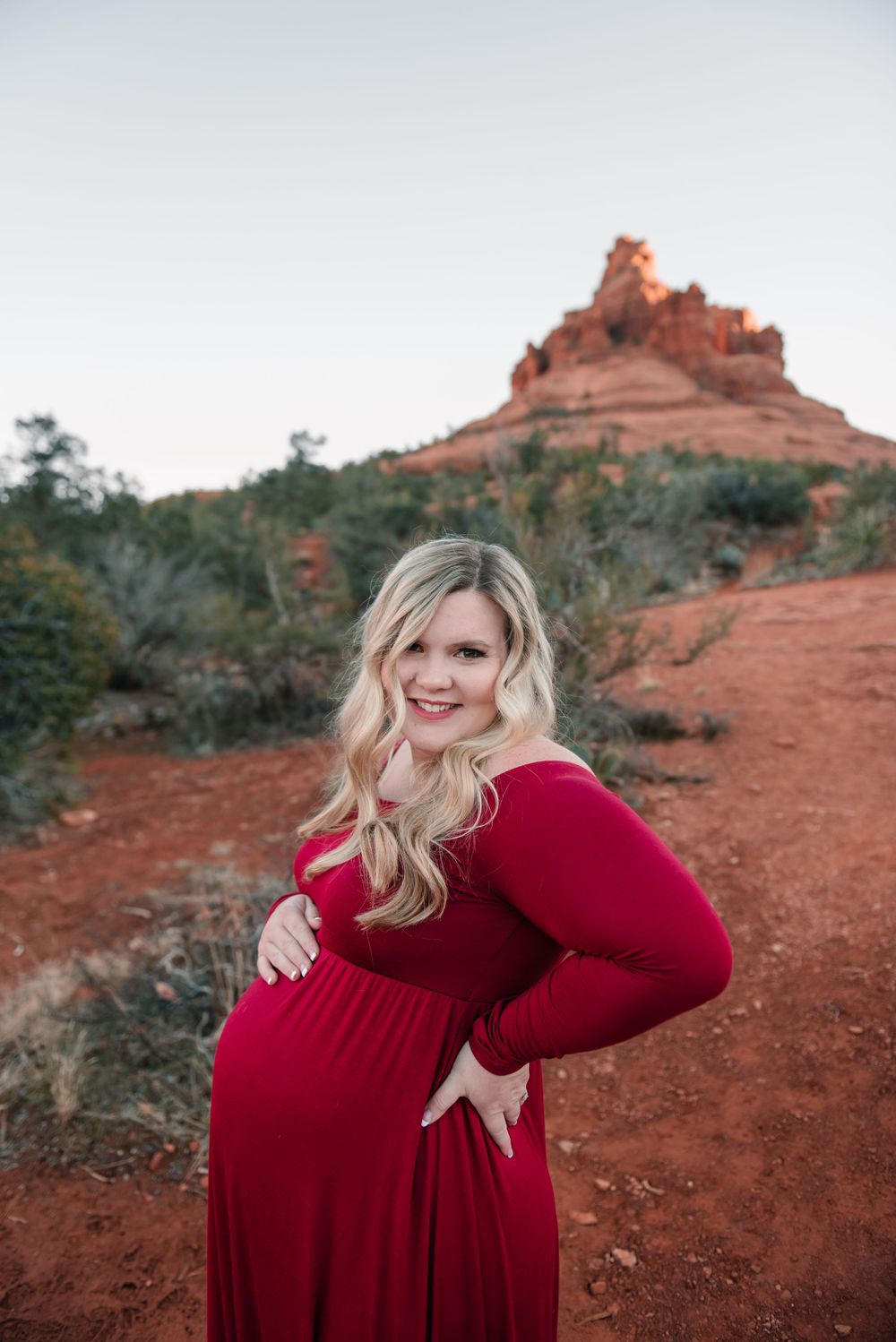 A joyful maternity photo session captured against Sedona's stunning red rock landscape.