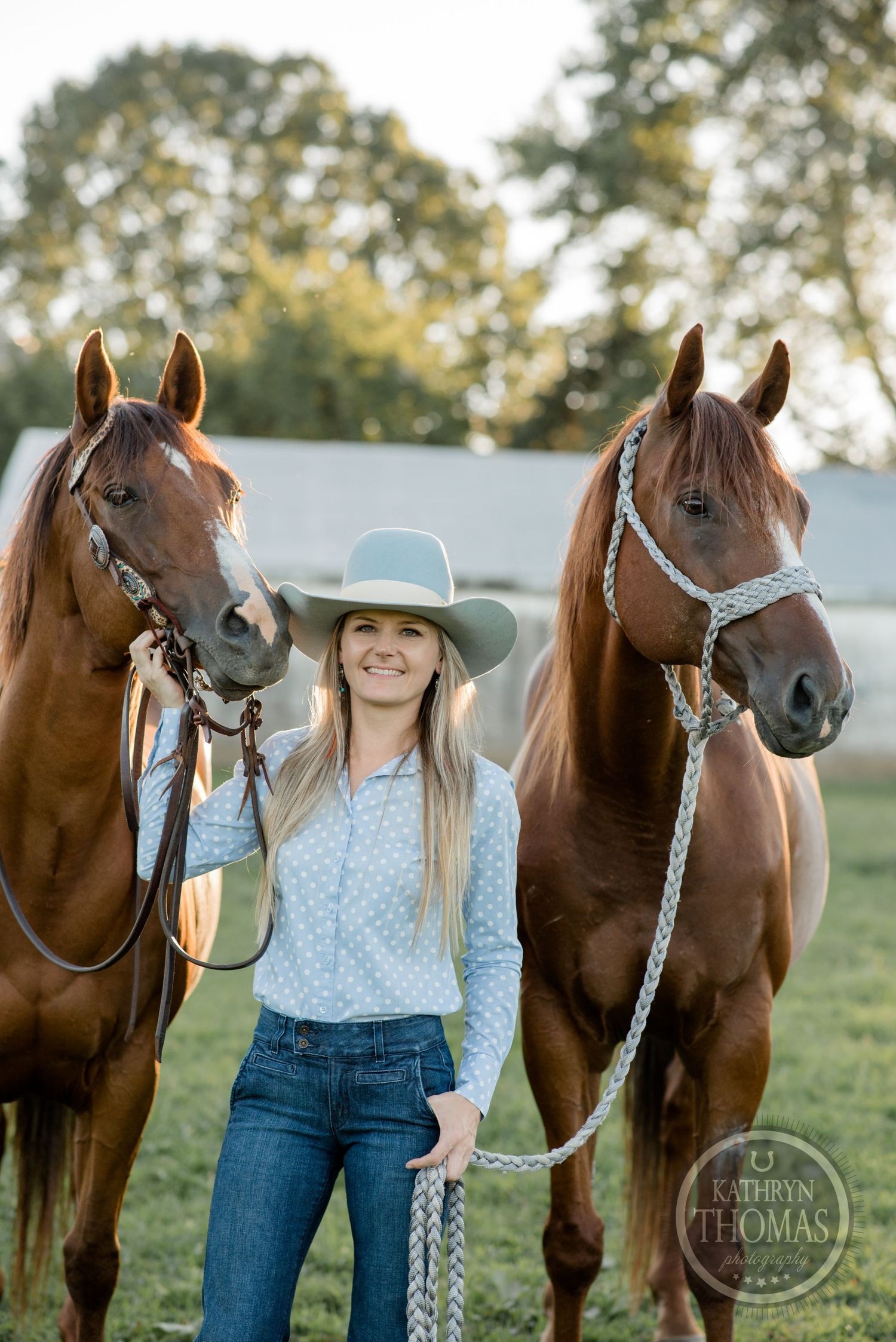 A western-style portrait featuring two brown horses and their handler in a blue shirt and gray hat.