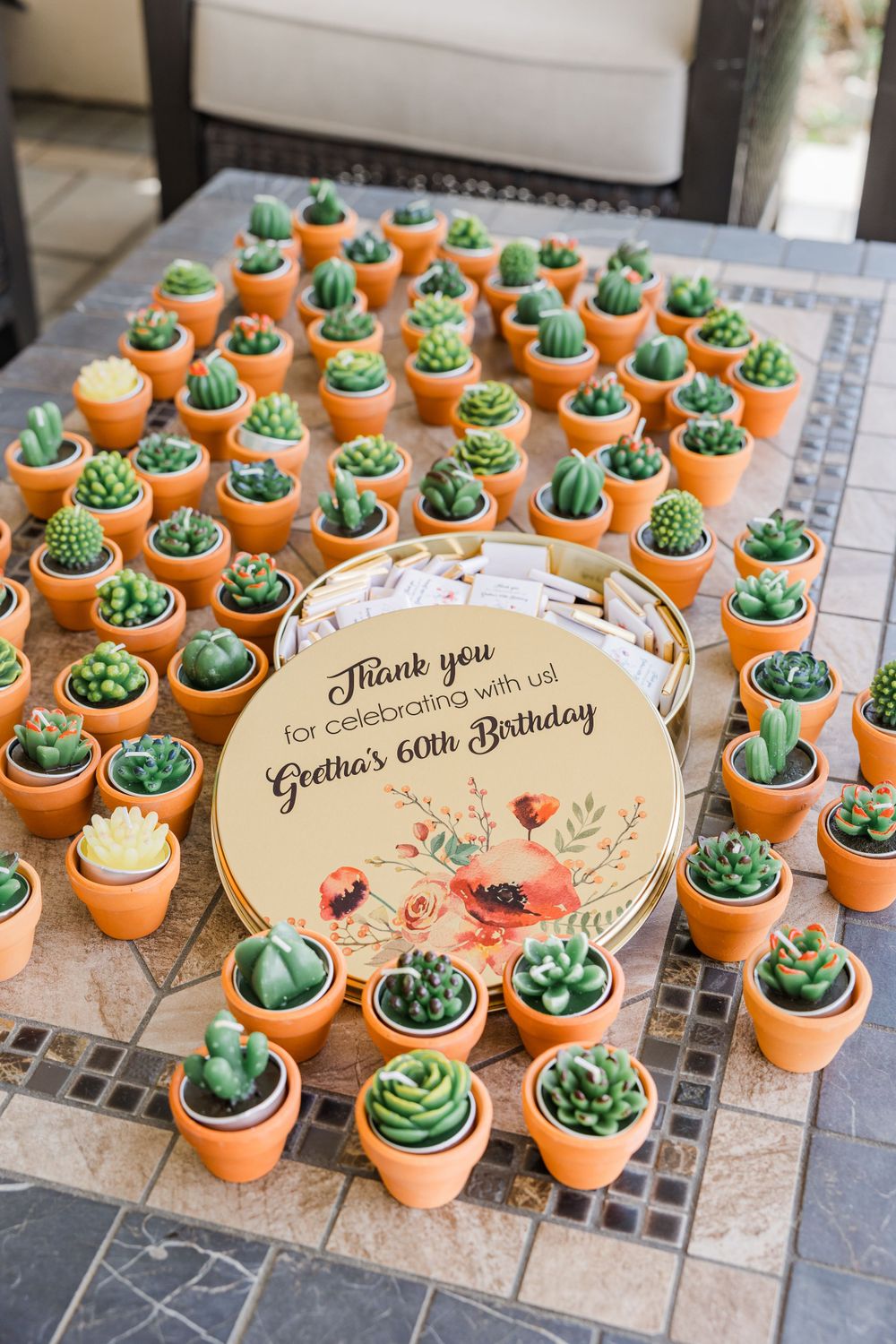 Miniature succulent party favors arranged around a floral thank you sign.