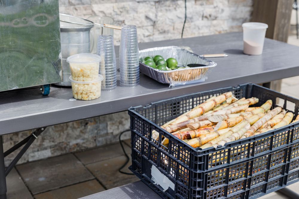 Fresh baked bread loaves cooling in black plastic crates on an outdoor counter.