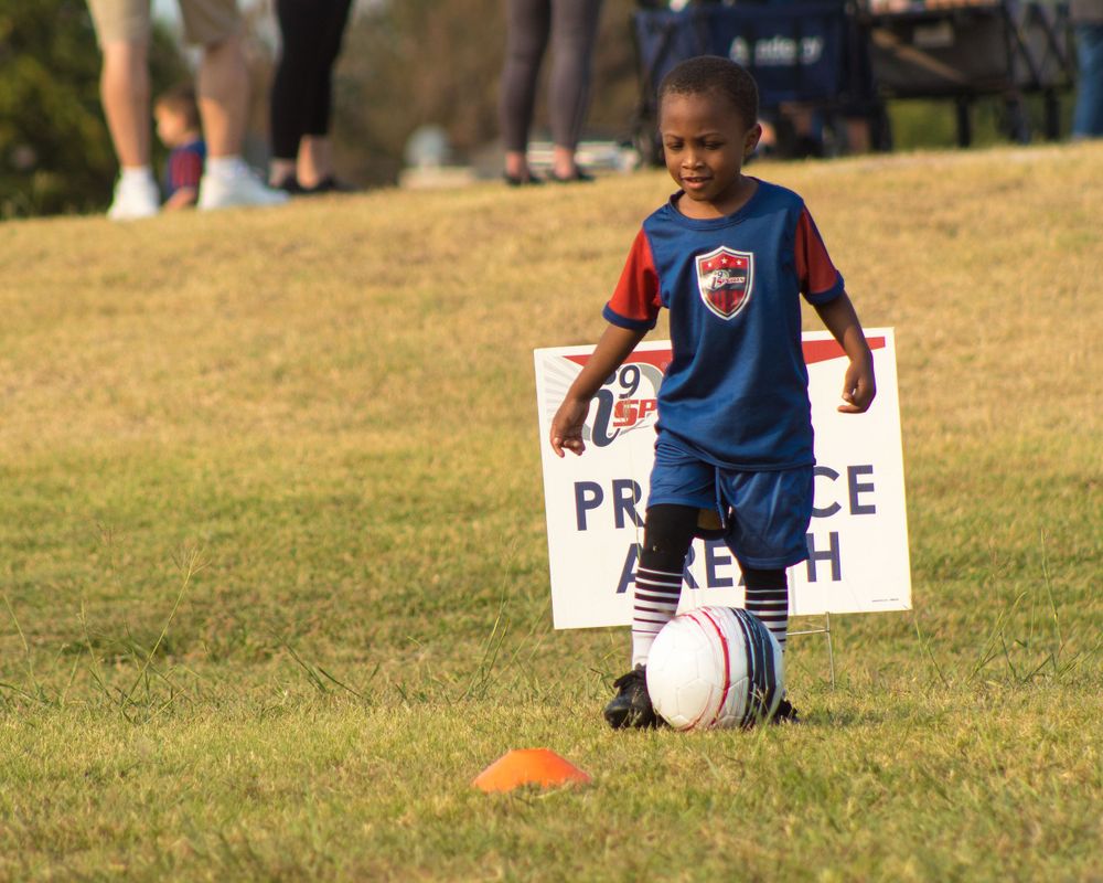 kid training with soccer ball