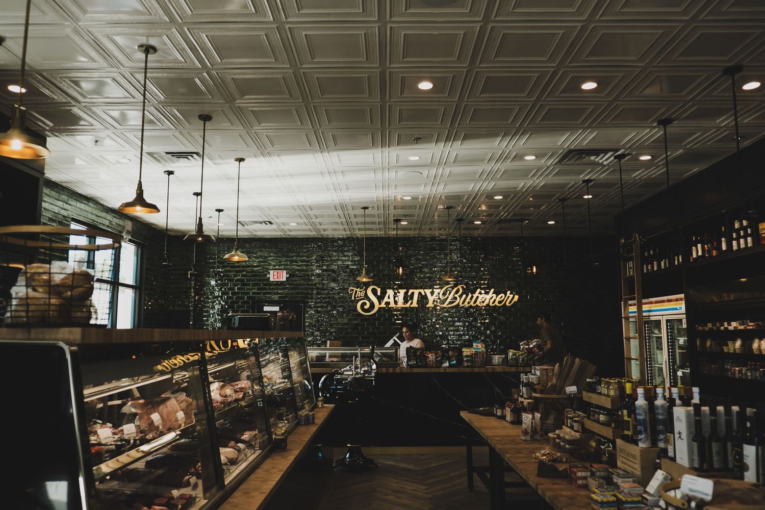 Dark moody interior of an upscale restaurant with ornate ceiling details.