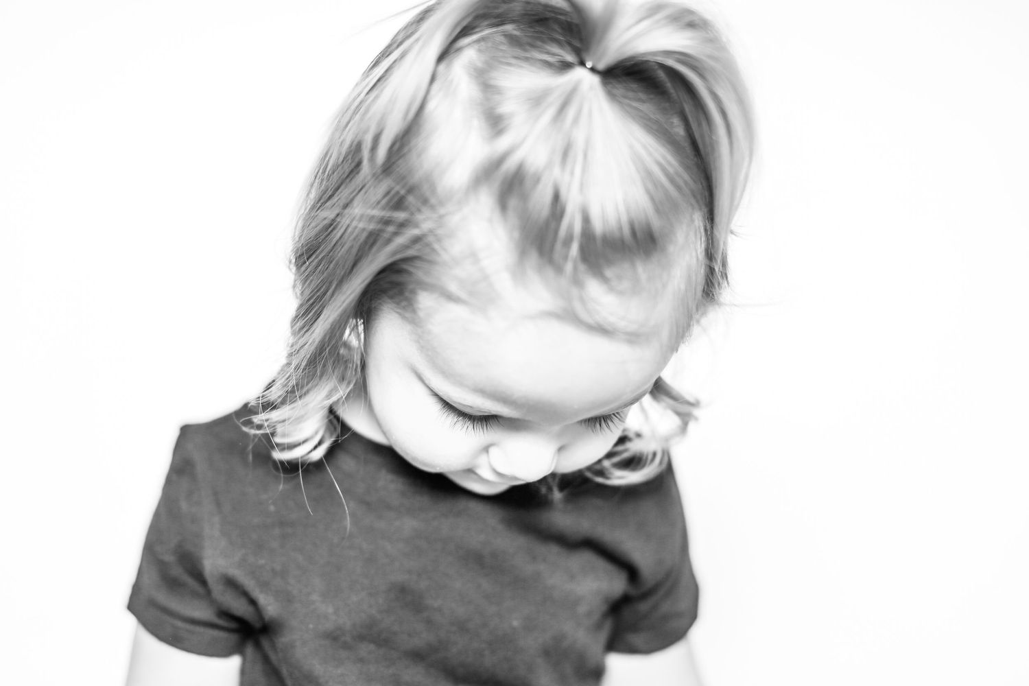 little girl looks down with curly hair in portrait by Stephanie Le Shana photography