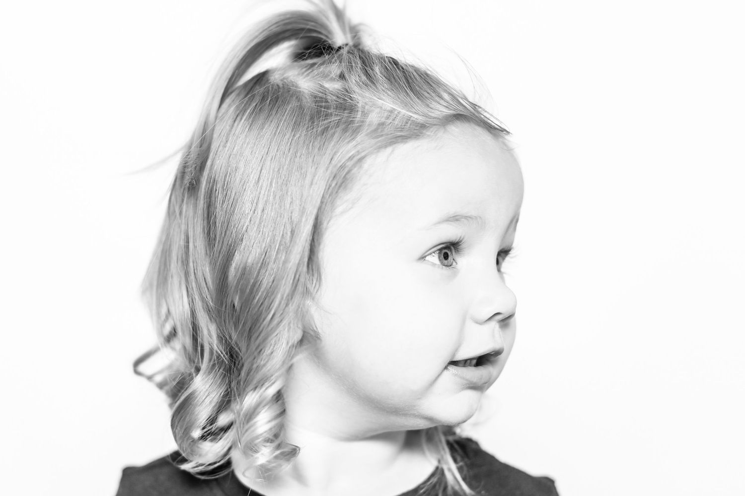 little girl looks to the side with slight smile in portrait by Stephanie Le Shana photography