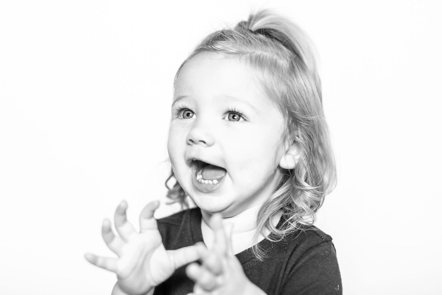 little girls claps and looks excited in portrait by Stephanie Le Shana photography