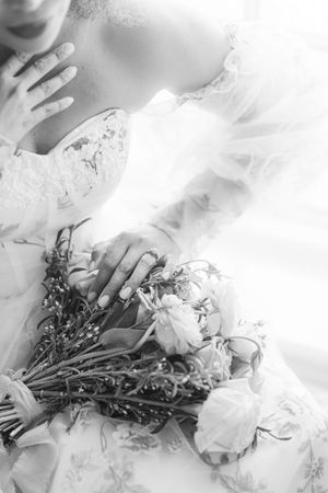 Dreamy black and white bridal portrait with white flowers and lace details.