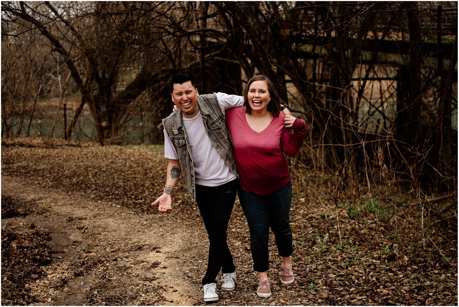 A playful moment captured on a dirt path surrounded by bare trees.