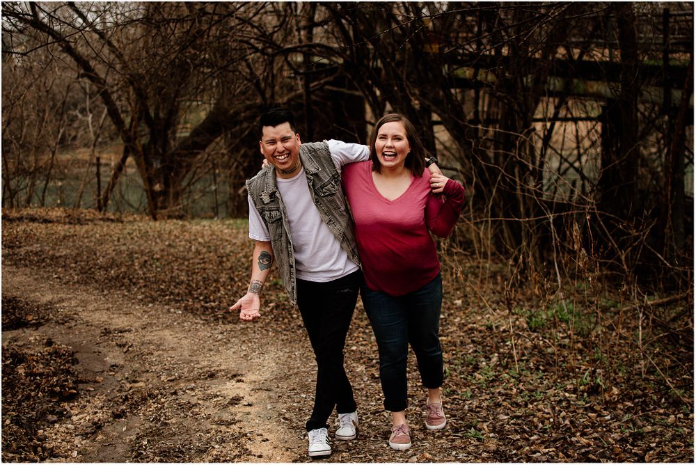 A playful moment captured on a dirt path surrounded by bare trees.