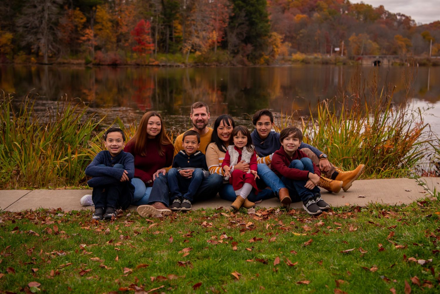 family of eight sitting in front of north park lake