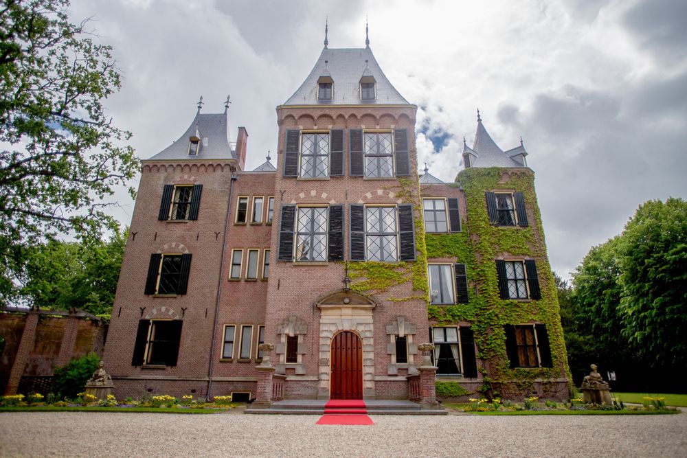 Majestic historic castle with red carpet entrance and ornate architecture.