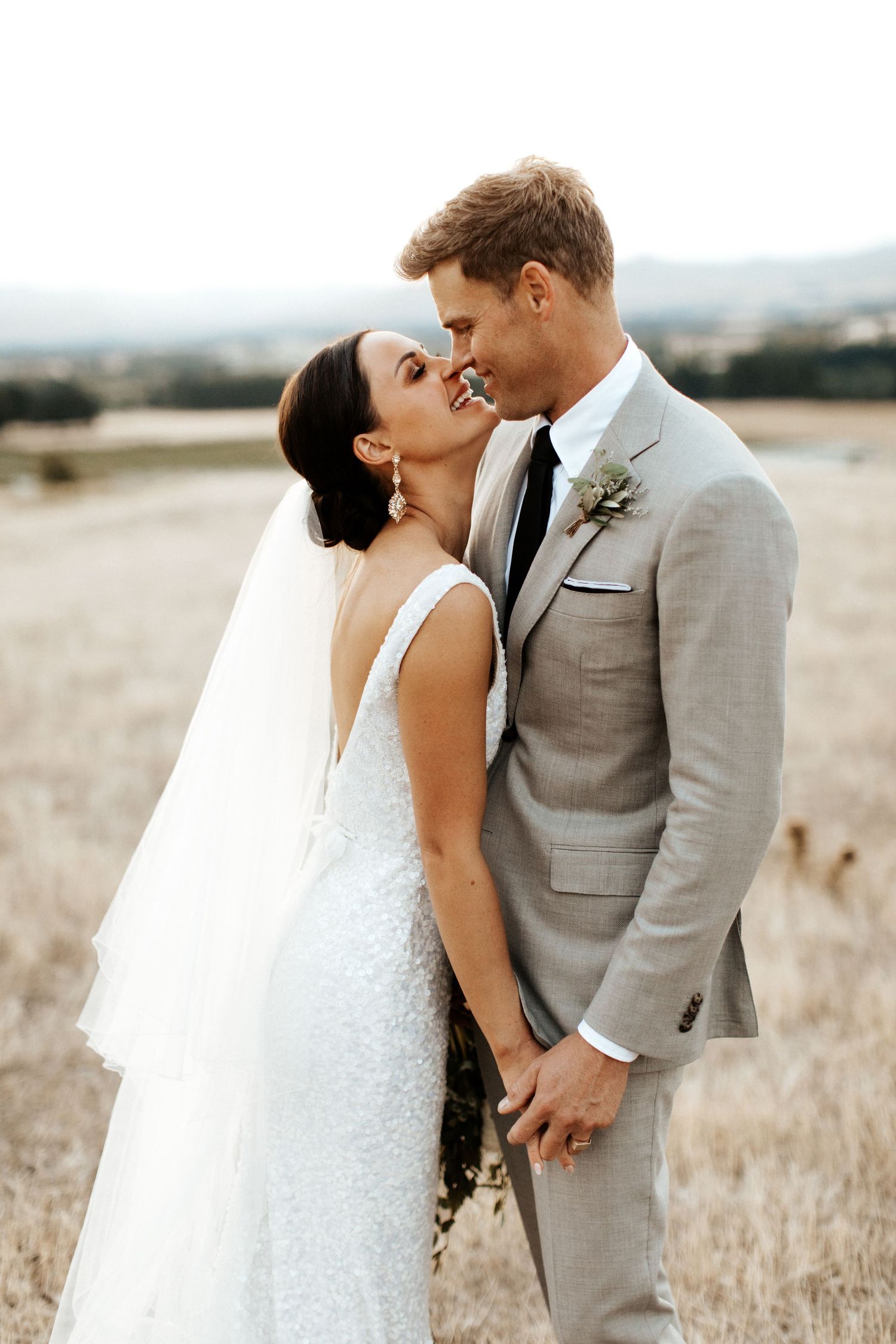 Intimate wedding portrait captured against scenic mountain landscape.