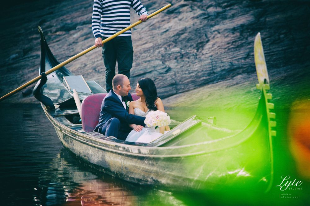 a bride and groom sitting on a gondola in the water, in the style of cross-processing/processed