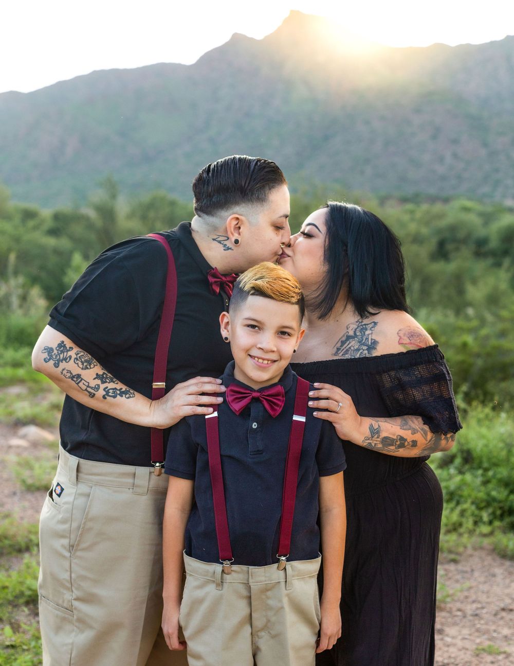 Family posing together against a scenic mountain backdrop at sunset.