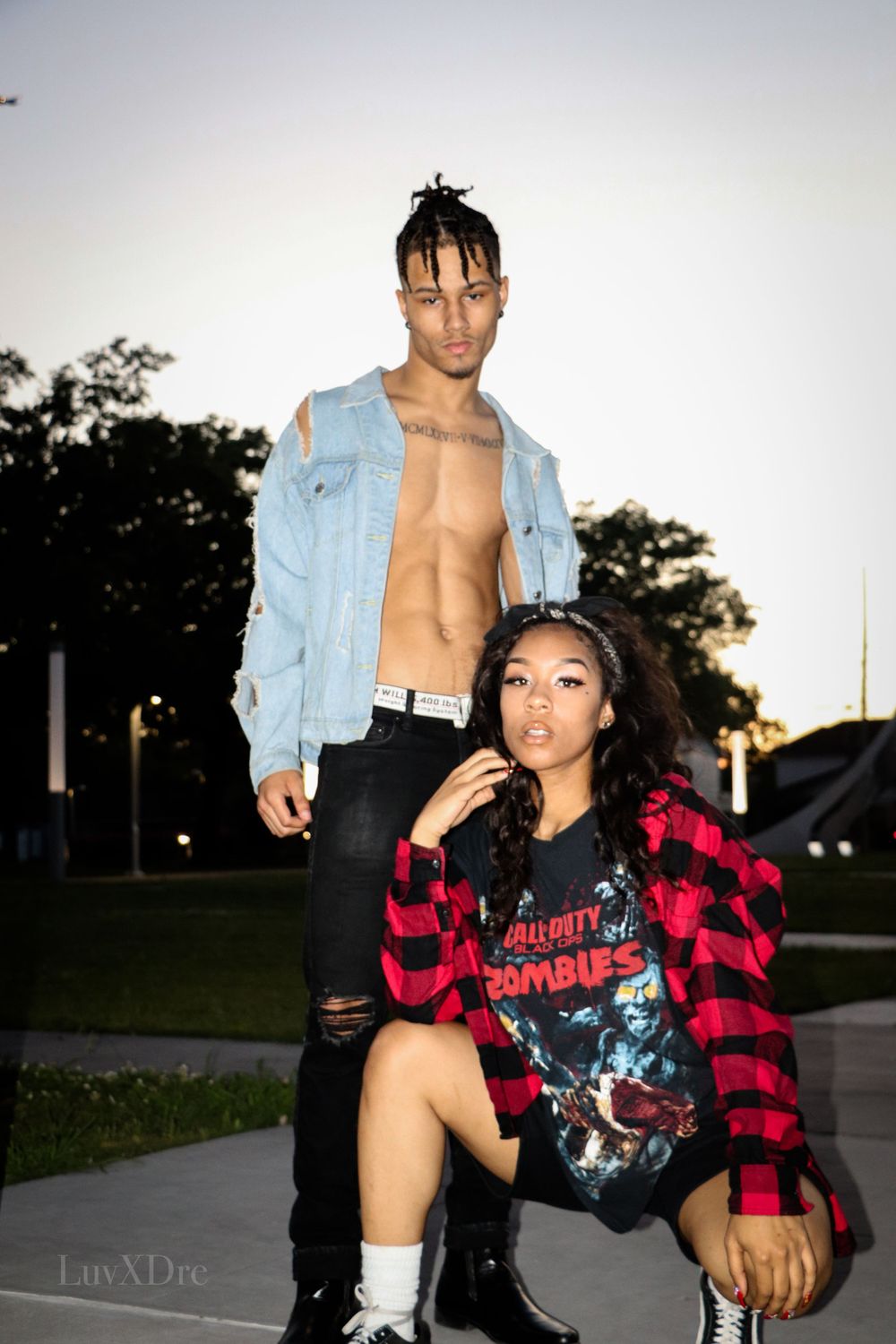 Fashion shoot featuring denim jacket and red plaid flannel at sunset outdoors.