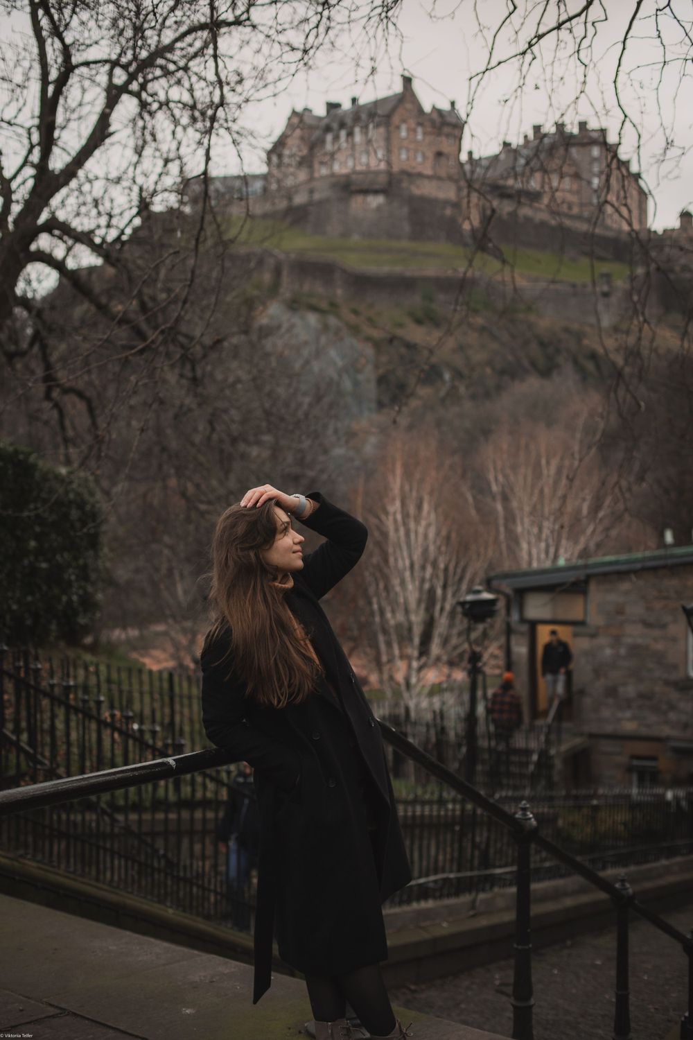 Moody architectural photos of Edinburgh Castle on a cloudy day with dark railings in the foreground.