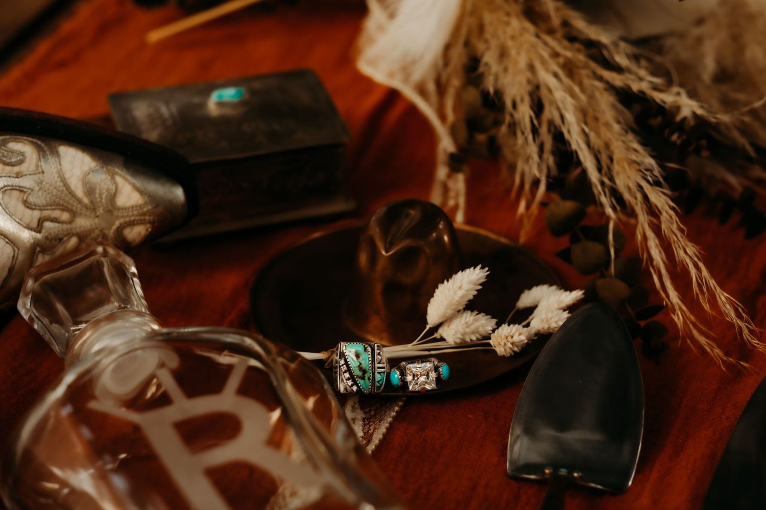 Artistic flat lay of wedding decor elements with rustic textures and warm tones against a dark background.