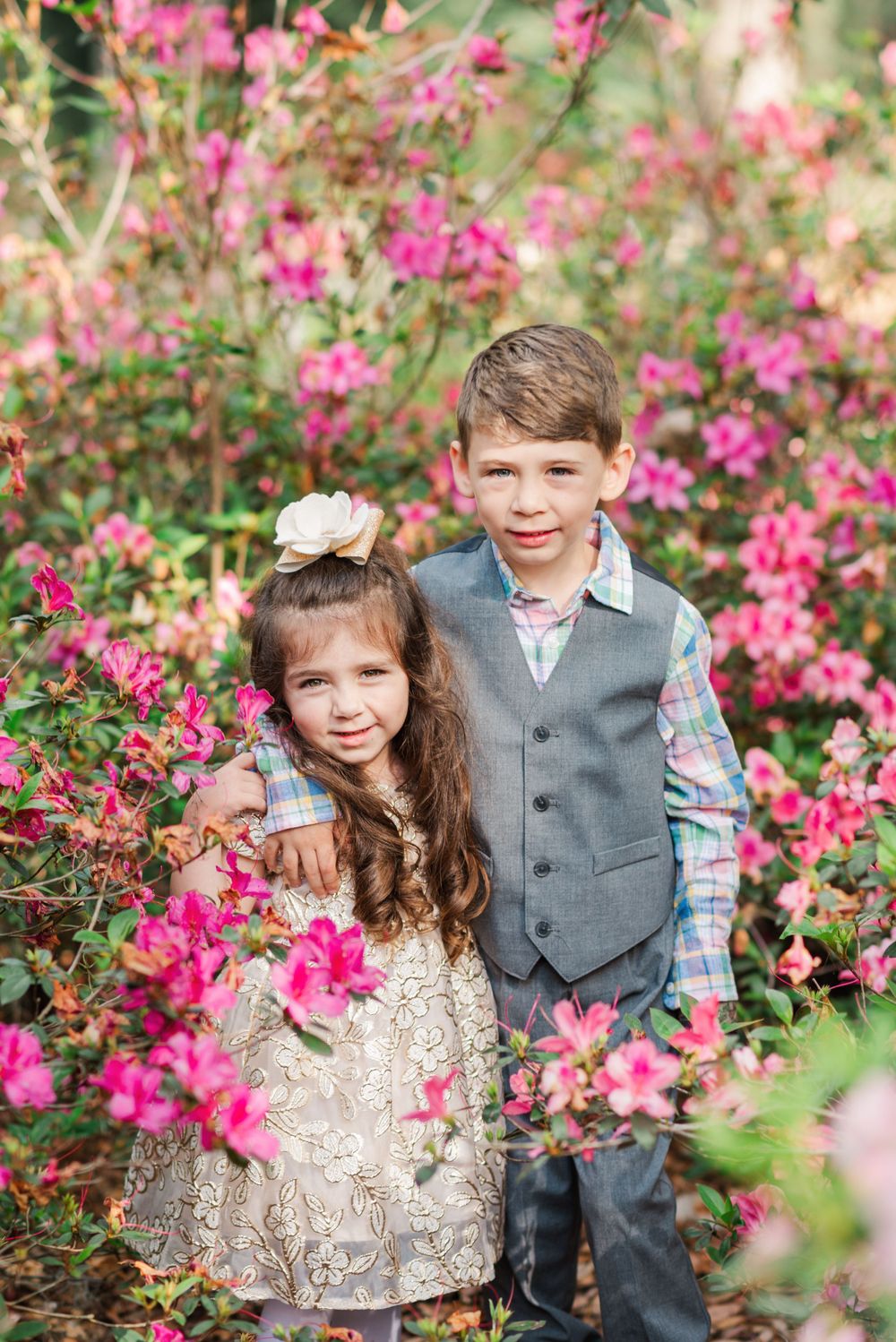 two children pose among the azalea bushes at Bok Tower Gardens in Lake Wales, Florida