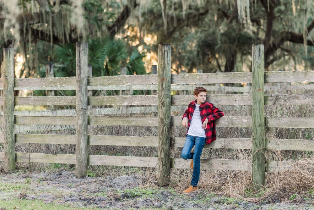 young boy stands against fence railing at Circle B Bar Reserve in Lakeland, Florida