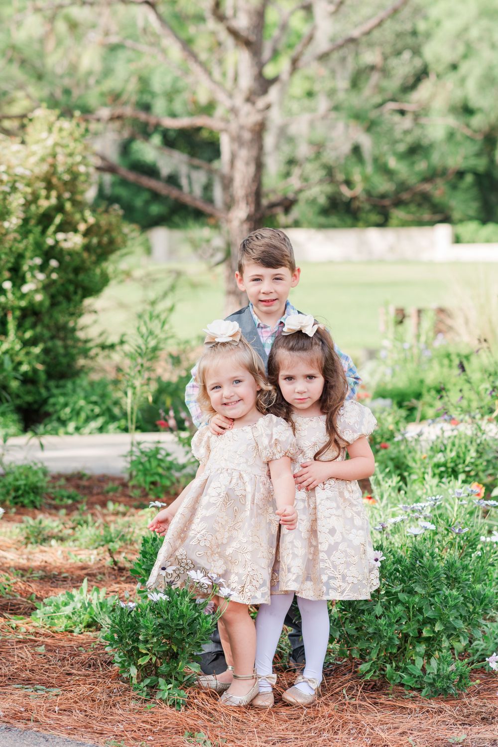 three children stand among the flowers at Bok Tower Gardens in Lake Wales, Florida