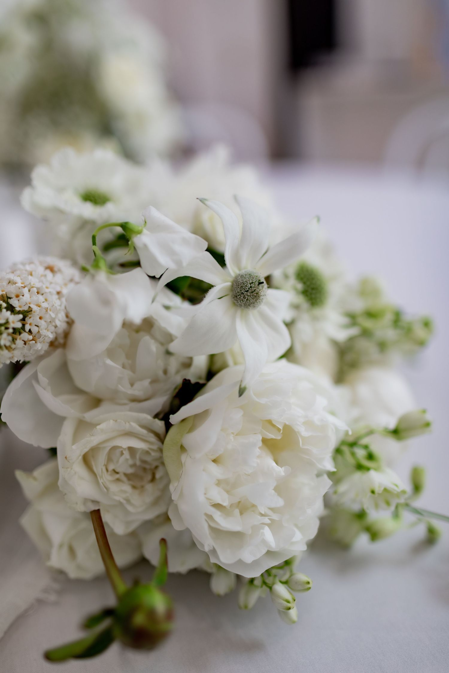 Close-up of white garden roses and delicate florals in an elegant arrangement.