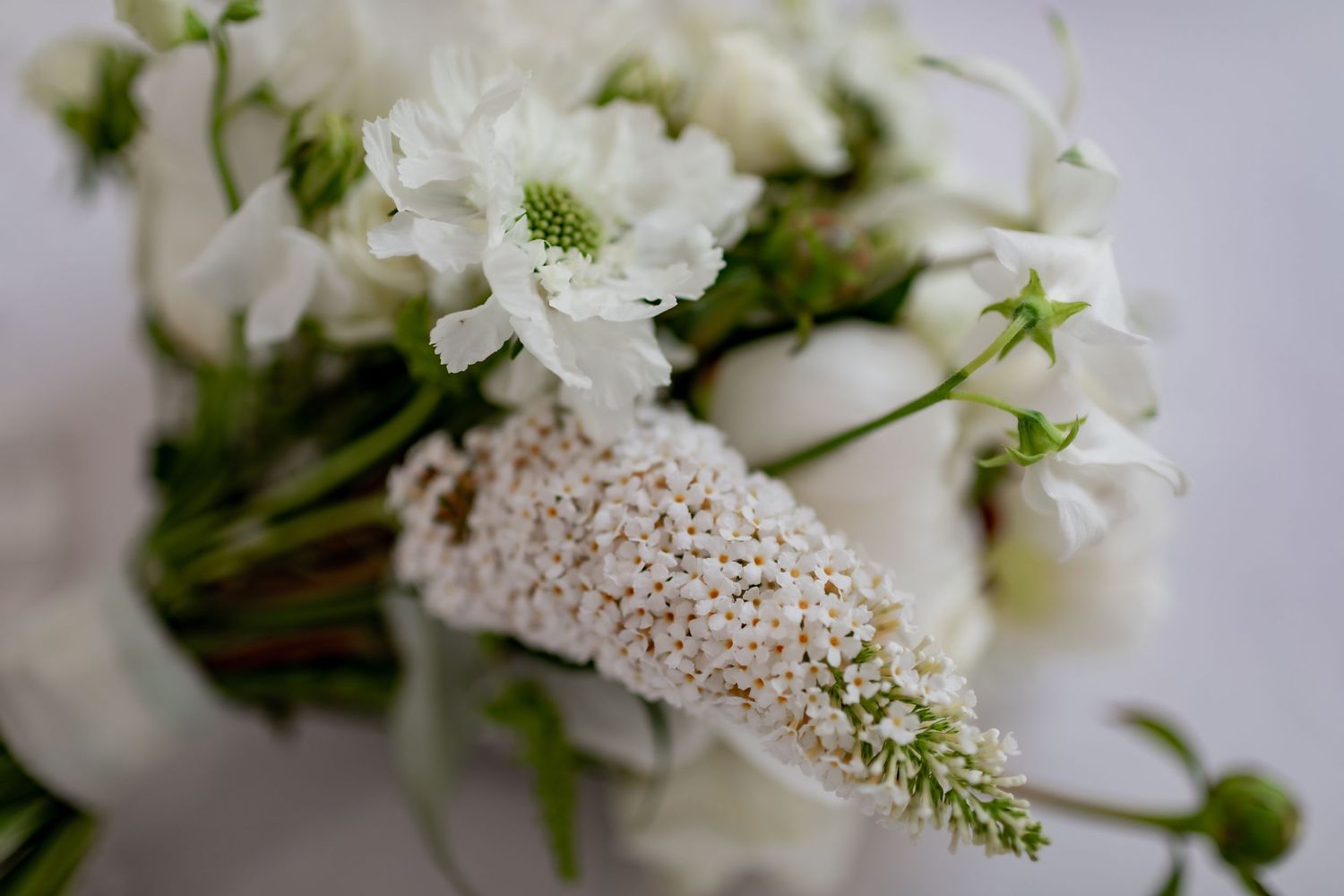 Delicate white flowers and lace details in a romantic wedding arrangement.