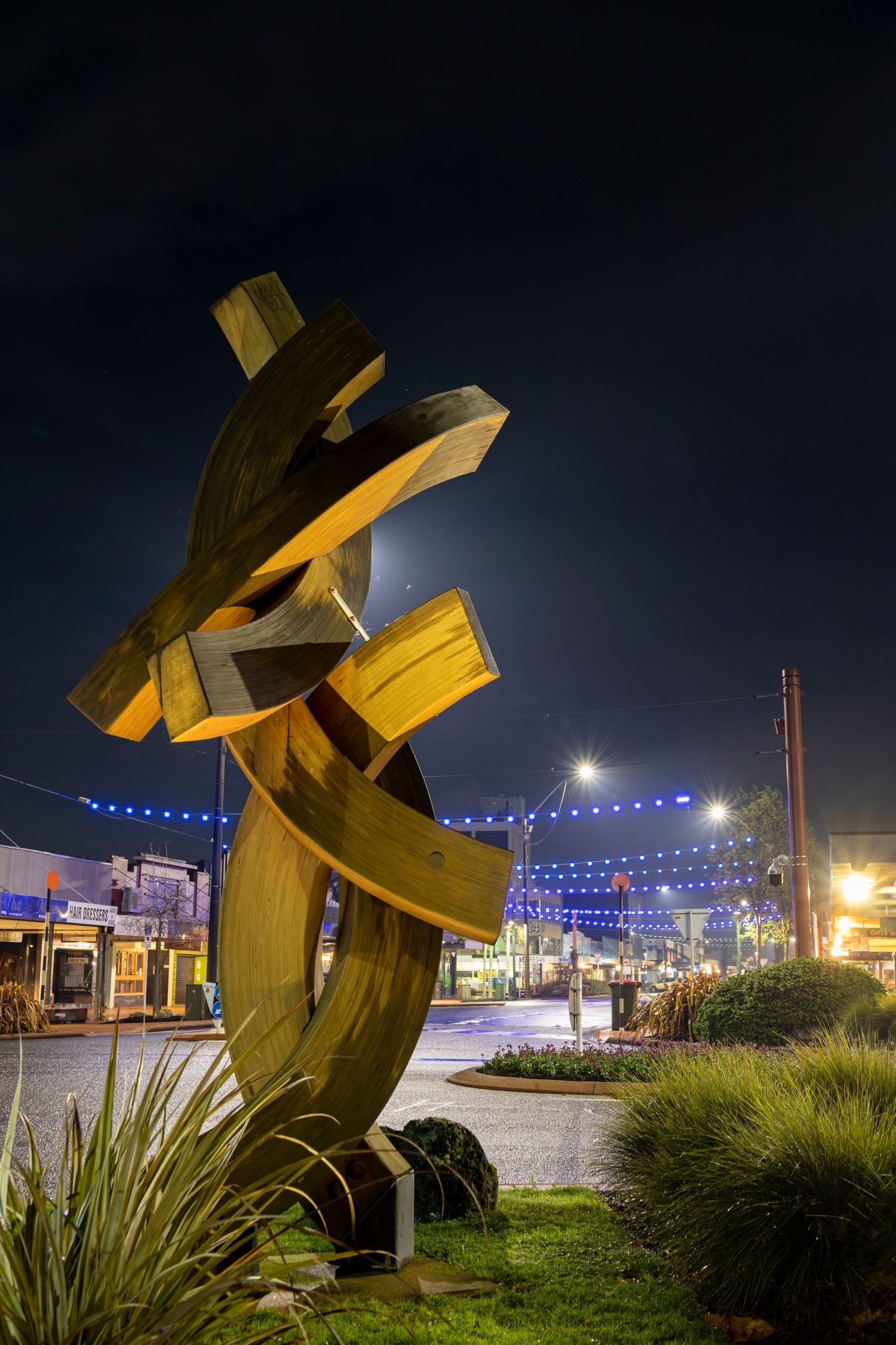 A twisting gold sculpture stands tall, catching the night lights on Auckland’s waterfront.