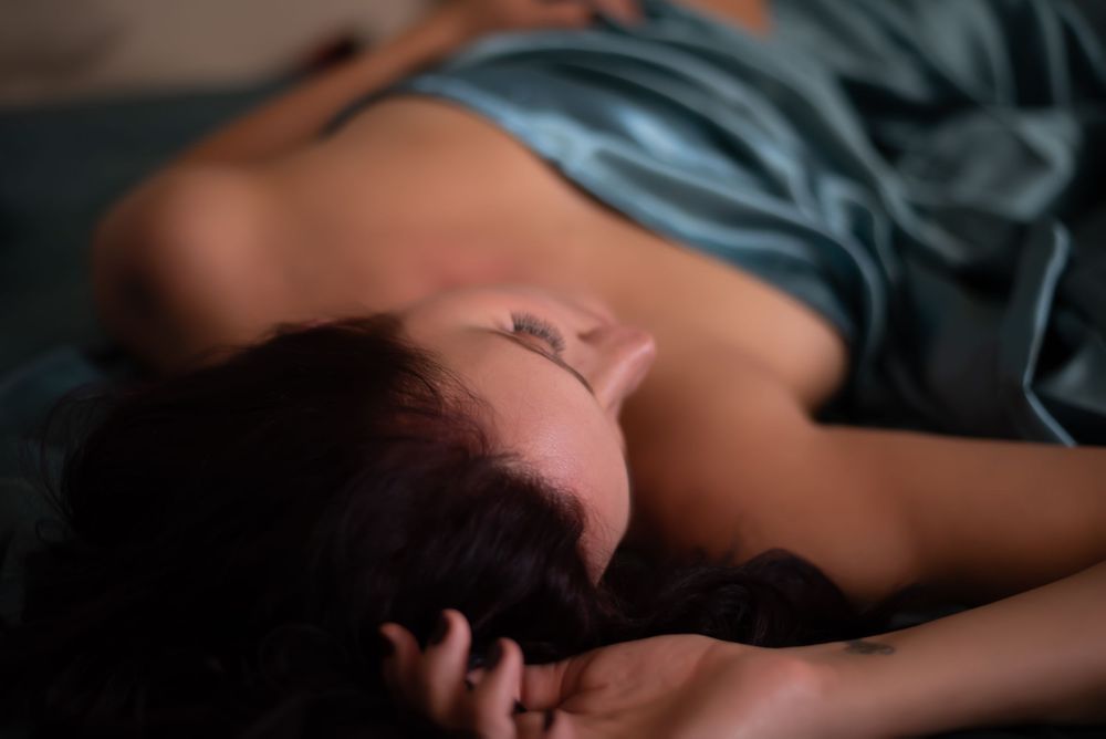 Brunette in teal sheets boudoir session.