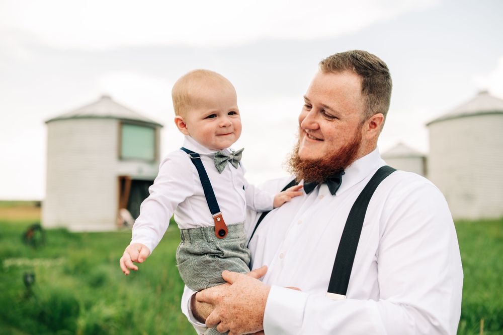 father and son, holding little boy smiling