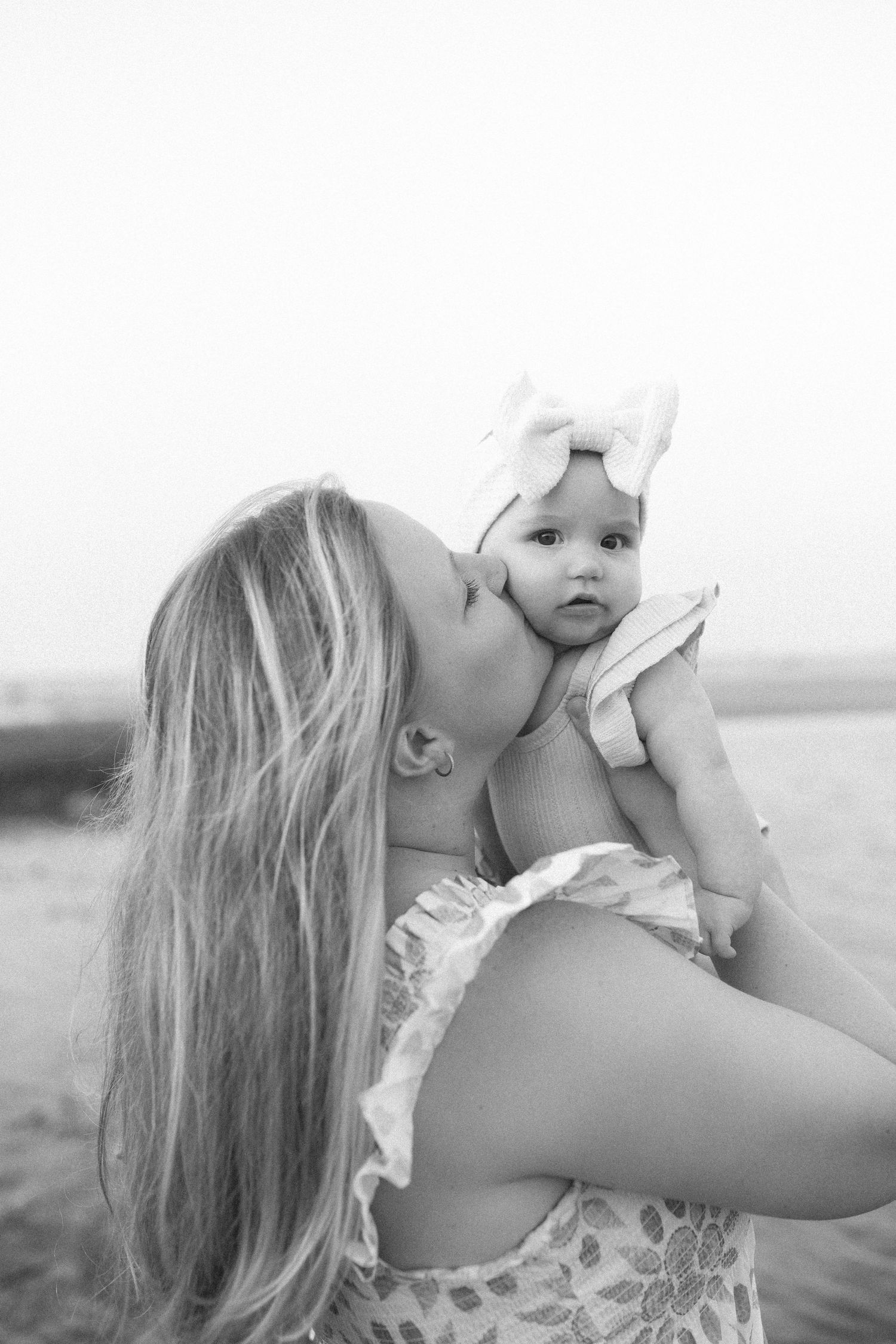 A black and white photo by B. Logsdon of a moment between mother and baby outdoors in the Lowcountry area of South Carolina.