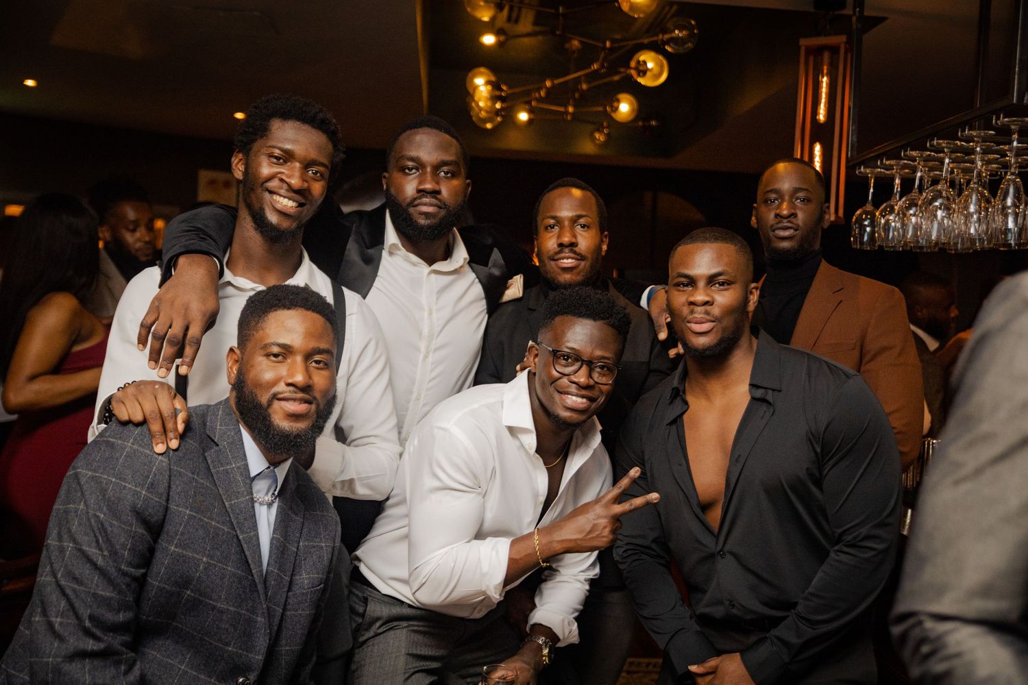 Well-dressed friends posing together at an elegant bar or restaurant celebration.