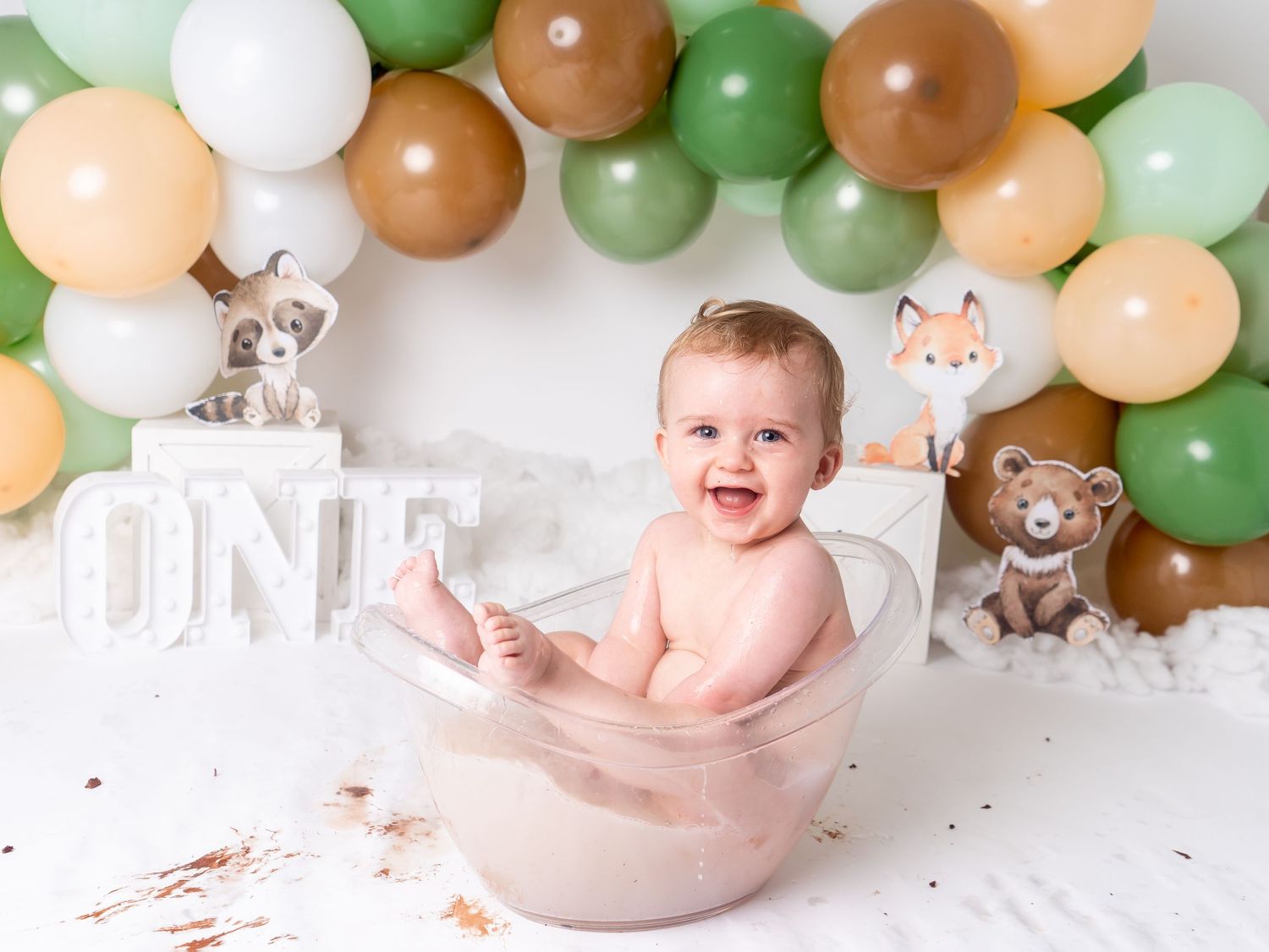 woodland cake smash session with boy laughing in bath tub for first birthday by newborn photographer in Doncaster.