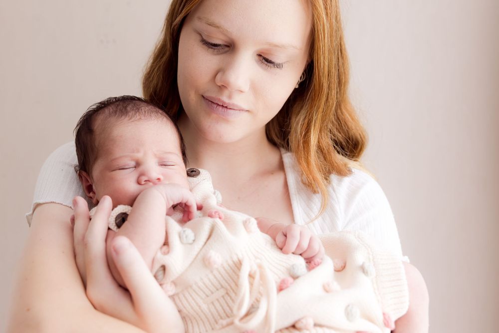 lady with long red hair holding baby