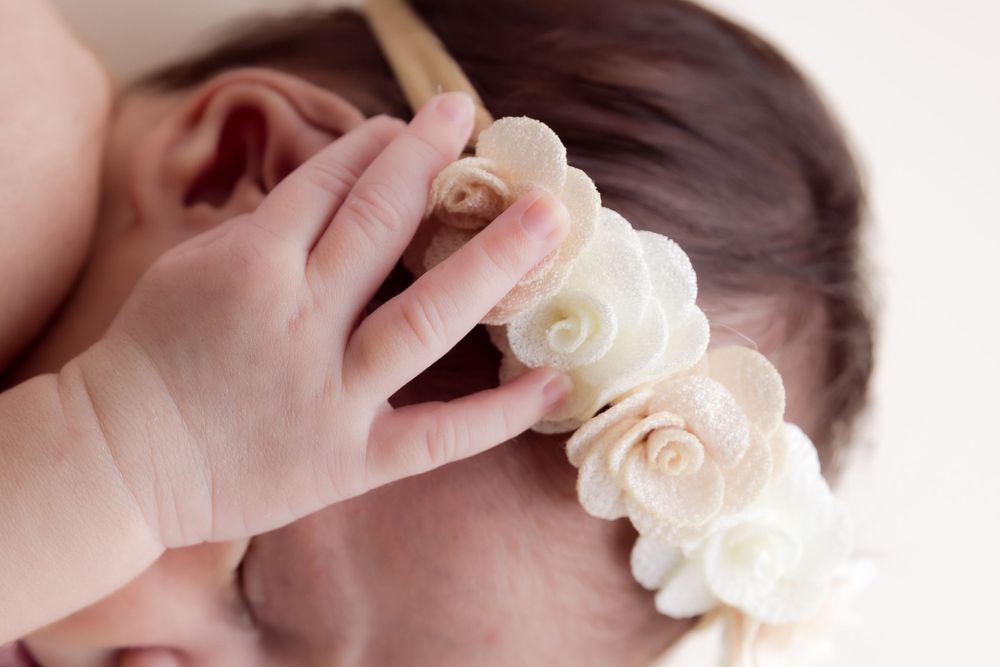 babys hand on flower headband