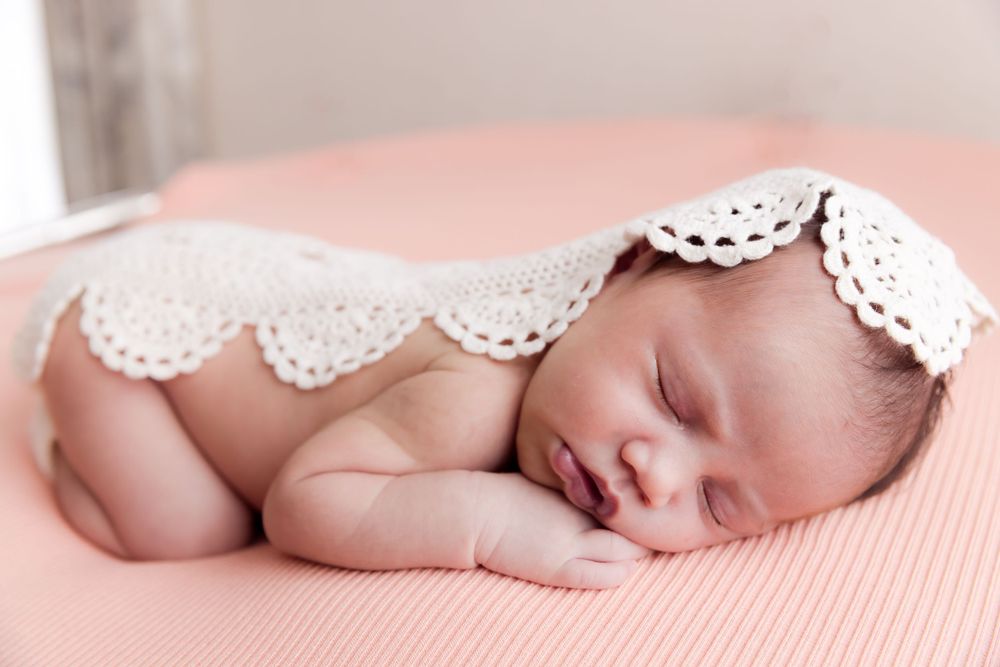 sleeping baby on peach blanket