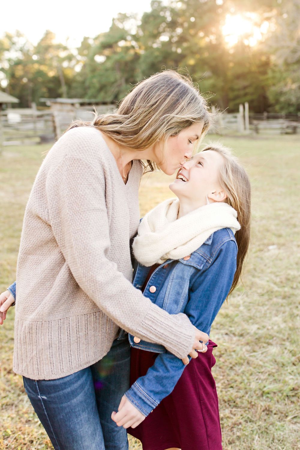 Sweet candid moment between parent and child embracing outdoors on a sunny afternoon.