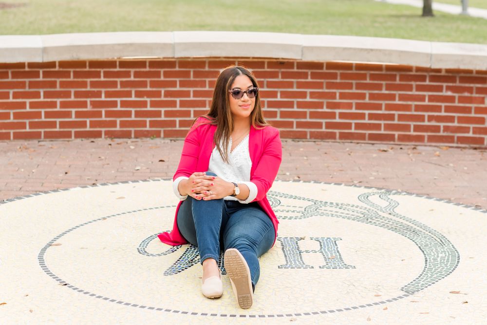 young woman sits on brick pavement in downtown Winter Haven, Florida