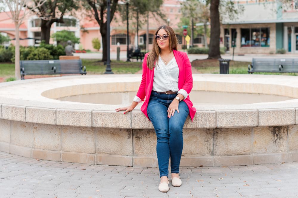 young woman poses on edges of fountain in downtown Winter Haven, Florida