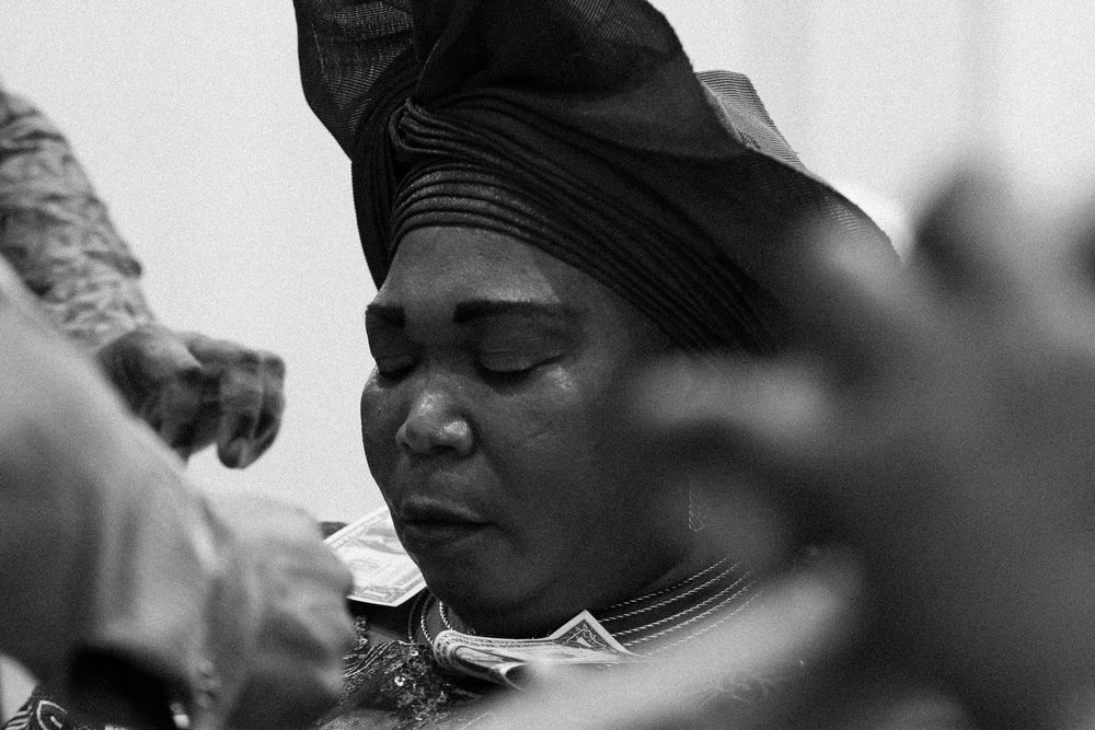 A black and white photo captures an intimate moment during a traditional ceremony.