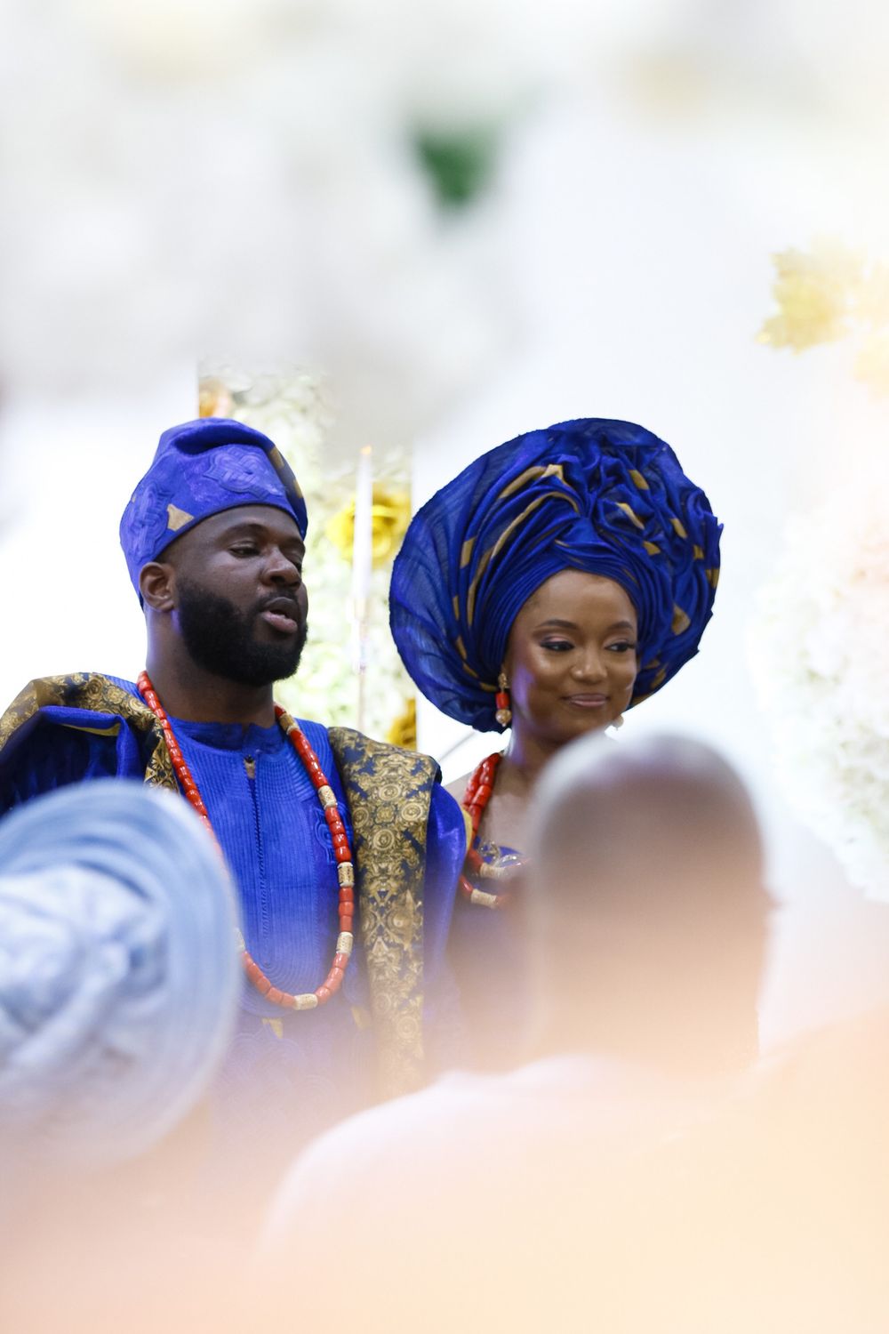 People in royal blue and gold traditional attire celebrate at a cultural event.