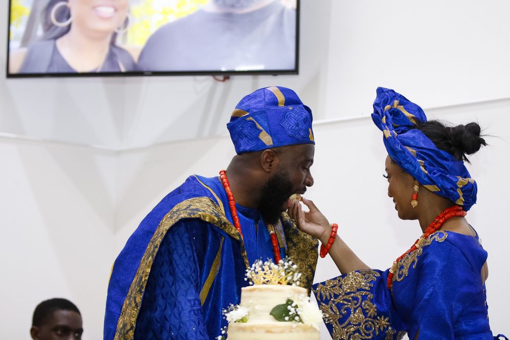People in traditional blue and gold attire interact during a cultural celebration.
