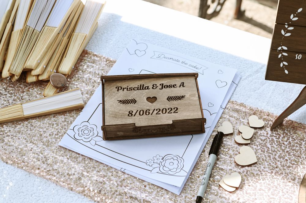 Personalized wooden wedding date book with ornate paper and decorative coins.