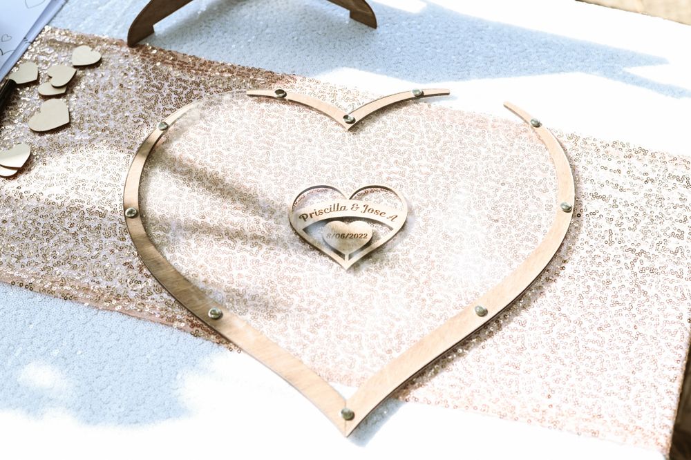 Heart-shaped metallic wedding decoration on sparkly table runner.