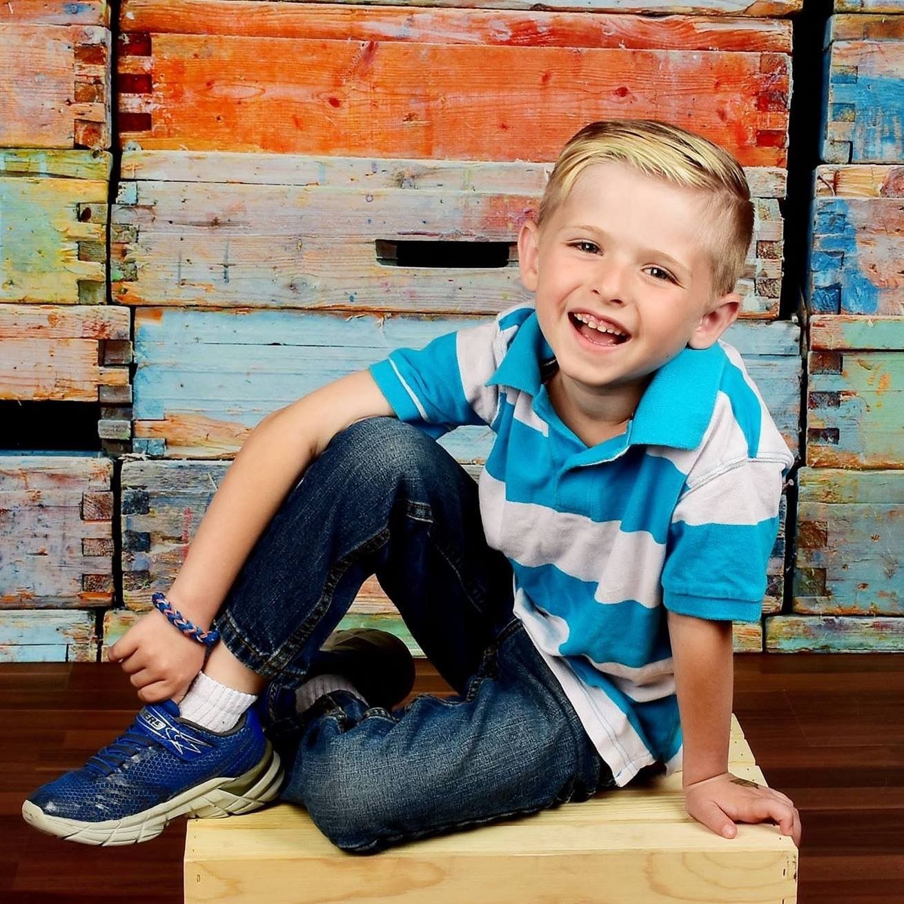 Casual portrait on wooden crate against distressed painted wall.