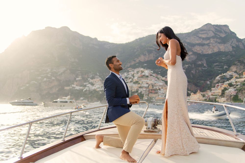 Photo shoot of a surprise proposal on a boat against Amalfi Coast  and Positano background.