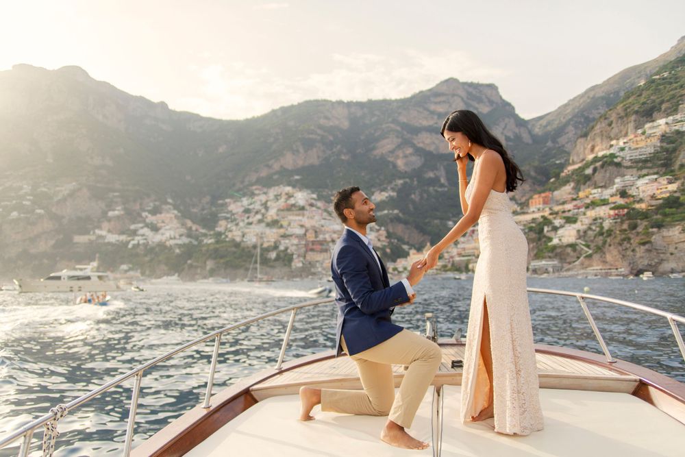 Photo shoot of a surprise proposal on a boat against Amalfi Coast  and Positano background.
