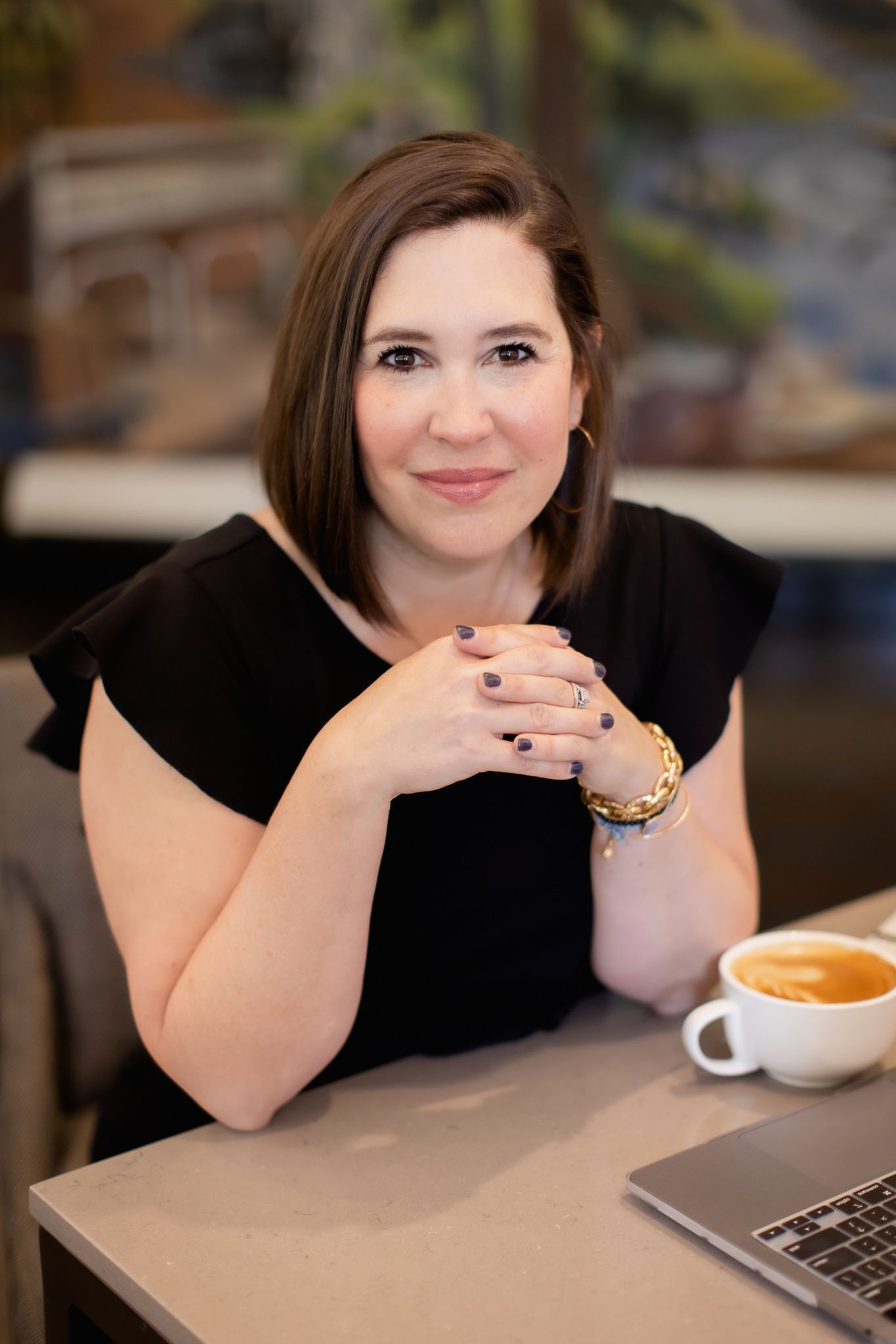 Katie Mill of KM Marketing social media storyteller for businesses woman sitting at table for branding headshots Seattle