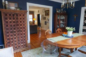 Rustic living room with navy blue walls, vintage furniture, and wooden accents arranged in a cozy layout.