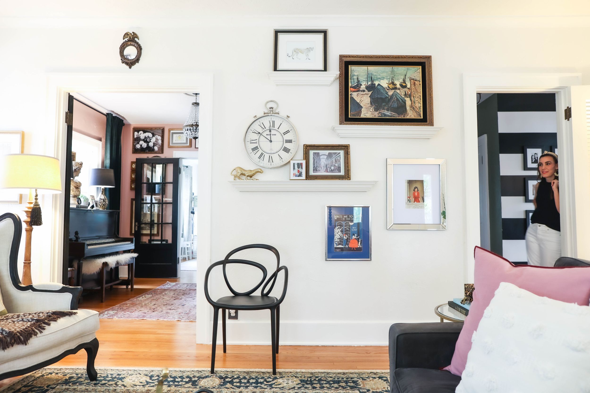 White living room wall decorated with framed artwork and modern black accent chairs.